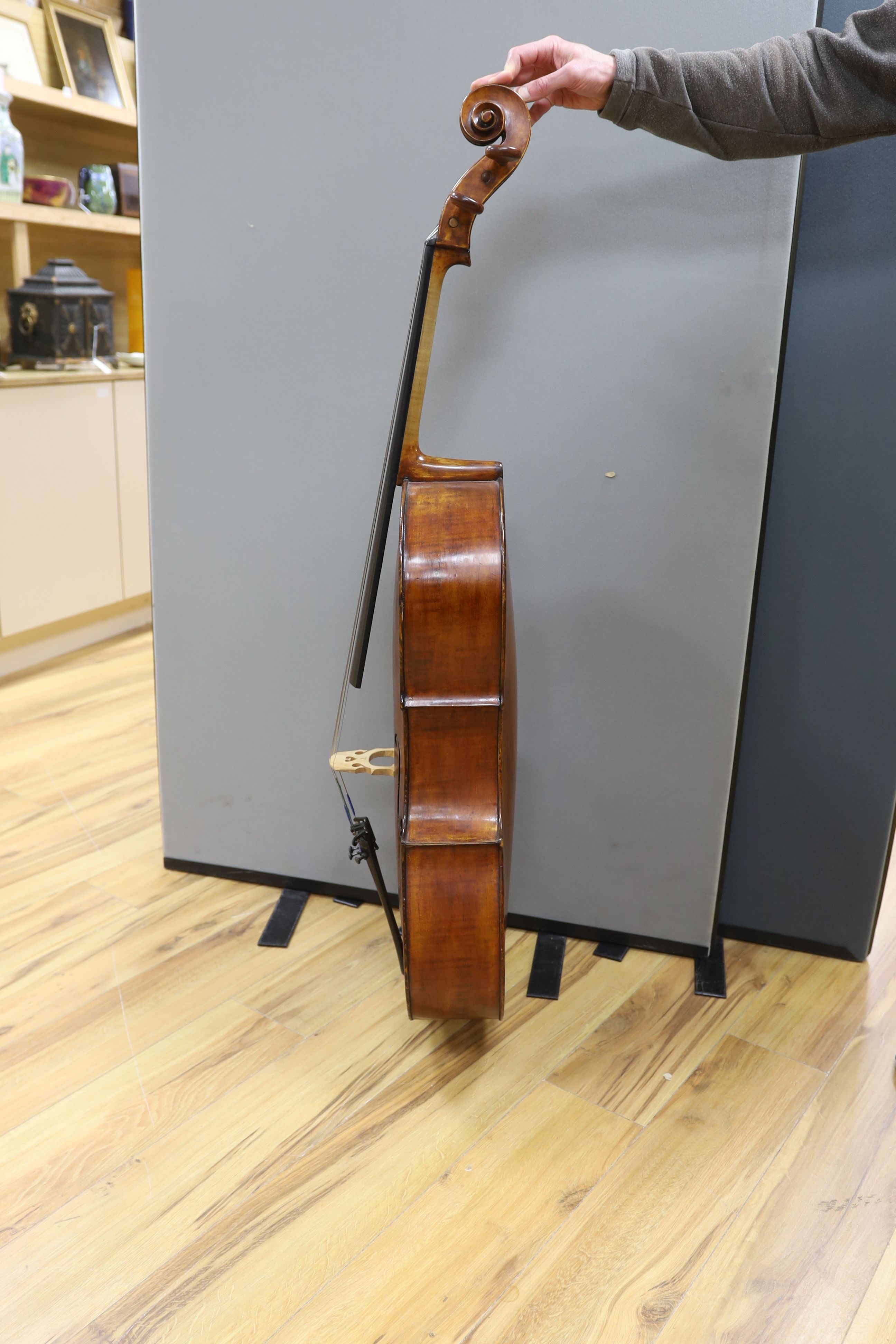 A cased early 20th century ‘cello, length of body 75.5cm, with two spare bridges, and spare strings
